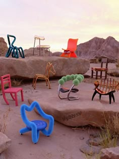 there are many different chairs on the ground in this desert area with rocks and grass