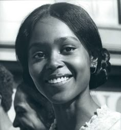 a black and white photo of a woman smiling