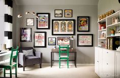 a living room filled with lots of framed pictures on the wall next to a green chair