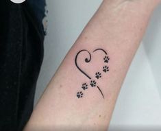 a person with a tattoo on their arm and paw prints in the shape of a heart