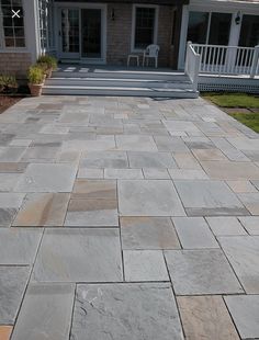 an outdoor patio with flagstone pavers and steps leading to the back porch area