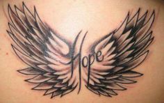 the back of a woman's neck with black and white wings on it,