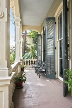 the front porch is lined with chairs and potted plants