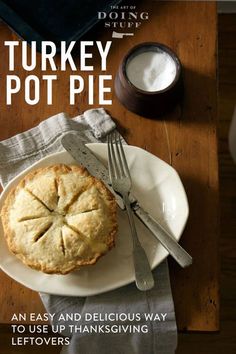 a turkey pot pie on a white plate with a fork and knife next to it