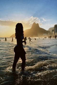 a woman is standing in the water at the beach