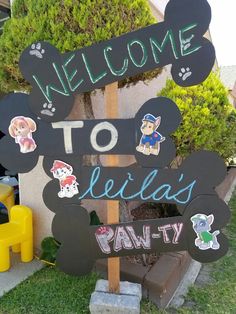 a welcome sign with stickers on it in front of a house and children's play area