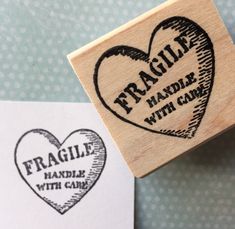 a rubber stamp with the words fragile handle with care and a heart shaped stamp that reads fragile handle with care