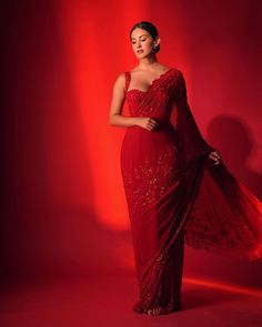 a woman in a red dress posing for the camera with her hand on her hip