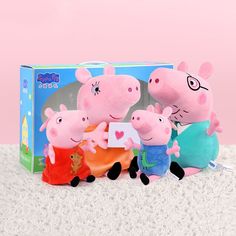 three peppa pig stuffed animals sitting next to each other on a white carpet in front of a pink background