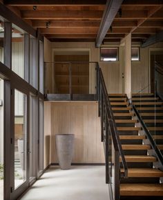 an empty room with stairs leading up to the second floor and a large vase on the ground