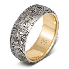 a wedding ring with an intricate design in gold and silver, on a white background