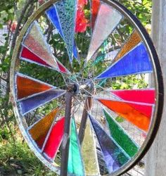 a colorful windmill wheel sitting on top of a wooden pole