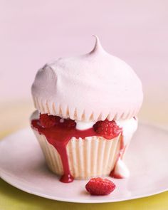 a cupcake with white frosting and raspberry toppings on it's top