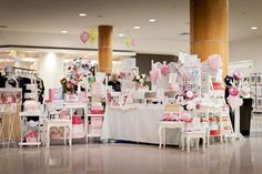 a room filled with lots of tables and chairs covered in pink and white decorations on top of each table