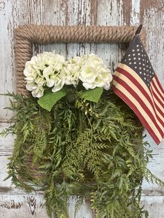 an american flag and flowers are hanging on a wall