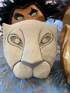 two paper mache masks are sitting on a table