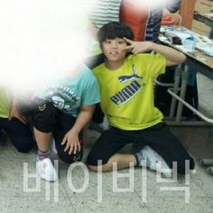 two young boys sitting on the ground next to each other