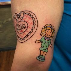 a girl with a heart tattoo on her arm next to a drawing of a doll