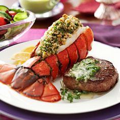 lobster, steak and salad on a white plate