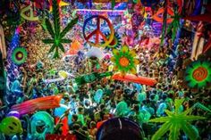 a large group of people at a festival with peace signs on their heads and hands