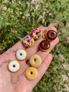 a person is holding five different donuts in their hand, including one with chocolate and sprinkles