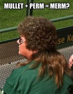 a woman sitting on top of a metal bench in front of a green grass covered field