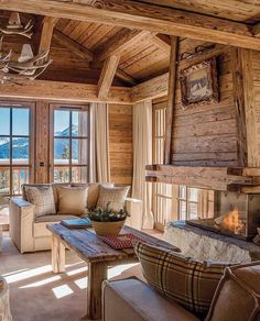 a living room filled with furniture and a fire place in front of a window overlooking the mountains