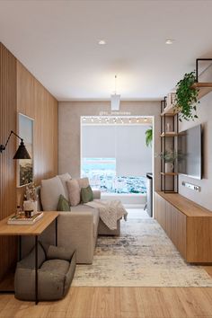 a living room filled with furniture and a flat screen tv mounted on a wall next to a window