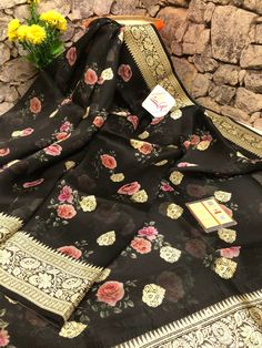 With detailed digital print work done with intricate detail makes this designer collection one of the sorted and unique buys to try for any light occasion or party in a great onyx black color. It is beautifully paired with woven zari work on the border and the pallu and mandala butta work on the body makes this saree unique. Color: A shade of onyx black color Technique: Amazing work of traditional zari weaving on the whole saree with digital floral print work on the body Fabric: Organza Quality: Semi-stitched Black Art Silk Blouse Piece, Party Georgette Blouse Piece With Printed Motifs, Designer Black Banarasi Silk Saree, Bollywood Style Floral Print Traditional Wear For Party, Bollywood Style Floral Print Traditional Party Wear, Designer Digital Print Saree For Eid, Party Blouse Piece With Traditional Drape And Printed Motifs, Multicolor Floral Print Traditional Party Wear, Traditional Party Wear With Printed Motifs