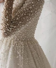 the back of a wedding dress with pearls on it