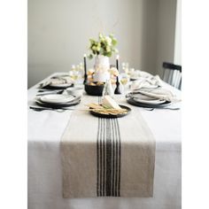 the table is set with black and white plates, silverware, and napkins