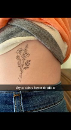 a woman's lower back tattoo with flowers on her left side ribcage