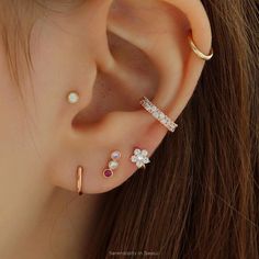 an ear with three different types of piercings