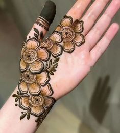 a woman's hand with henna tattoos on it