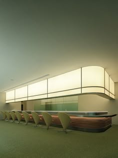 a row of chairs sitting in front of a counter with lights on top of it