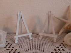 two wooden easels sitting on top of a doily next to a starfish