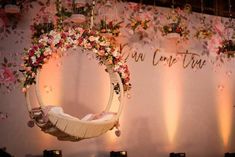 a baby's crib is decorated with flowers and hanging from the ceiling above it