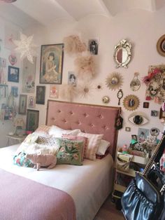 a bed sitting in a bedroom next to a wall filled with pictures and other items