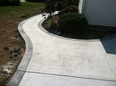 a concrete walkway in front of a house