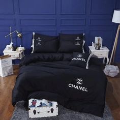 a bedroom with blue walls and chanel bedding on the floor in front of it