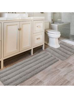 a bathroom with two rugs on the floor