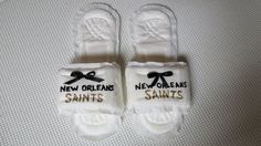 two new orleans saints slippers are sitting on a bed with the word new orleans printed on them