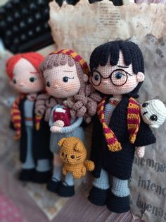 three knitted harry potter dolls are standing next to each other on a piece of paper