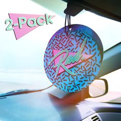 two - pack air fresheners hanging from the dashboard of a car with an abstract design