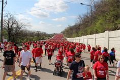 a large group of people in red shirts are walking down the street