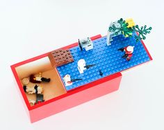 an overhead view of a lego table with two people sitting at the table and one person standing in front of it