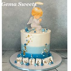 there is a cake with an angel on the top and letters below it that spell out congratulations