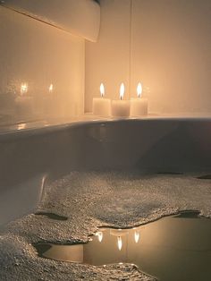 candles are lit in the middle of a bathtub