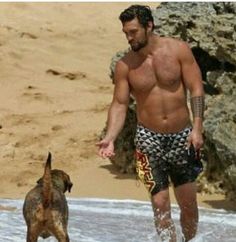 a man and his dog are playing in the water at the beach while on vacation