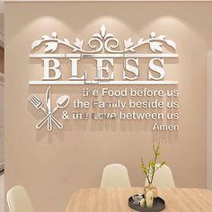 a dining room with a table and chairs in front of a wall that says, bless the food before us is the family beside us & then love between us amen